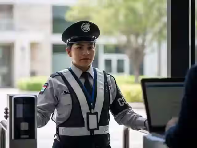 Elemento uniformado en el acceso de un corporativo, junto al lector de entrada
